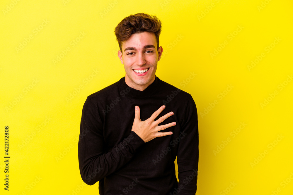 Young caucasian man isolated on yellow background laughs out loudly keeping hand on chest. Young caucasian man isolated on yellow background laughs out loudly keeping hand on chest.
