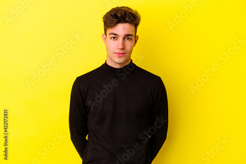 Young caucasian man isolated on yellow background sad, serious face, feeling miserable and displeased.