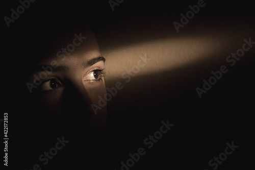 Canvas Print Single ray of light falling over girls eyes