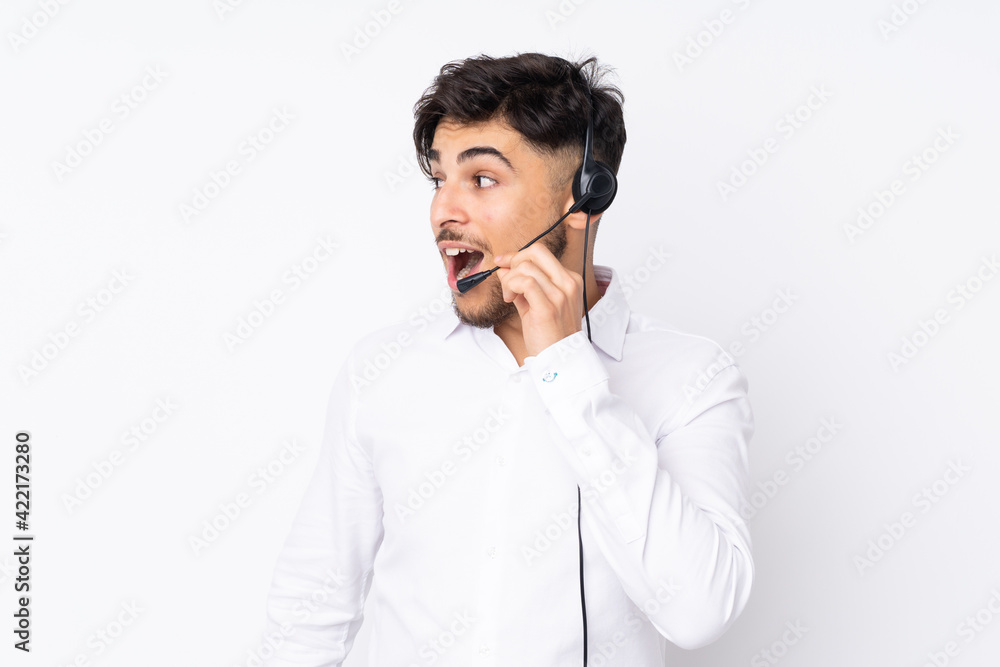 Telemarketer Arabian man working with a headset isolated on white background shouting with mouth wide open Telemarketer Arabian man working with a headset isolated on white background shouting with mouth wide open