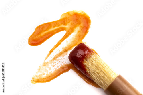 Wooden Culinary Brush Dipped in Barbecue Sauce on a White Background photo