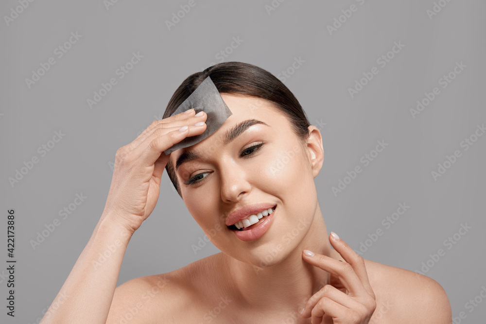 Skin Care. Woman removing oil from face using blotting papers. Closeup Portrait Of Beautiful Healthy Girl With Nude Makeup. Perfect Soft Skin With Oil Absorbing Tissue Sheets. Beauty Concept Skin Care. Woman removing oil from face using blotting papers. Closeup Portrait Of Beautiful Healthy Girl With Nude Makeup. Perfect Soft Skin With Oil Absorbing Tissue Sheets. Beauty Concept