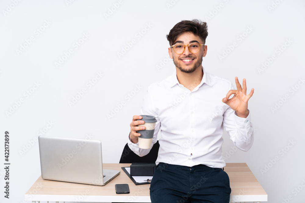 Arabian man in a office isolated on white background showing an ok sign with fingers Arabian man in a office isolated on white background showing an ok sign with fingers