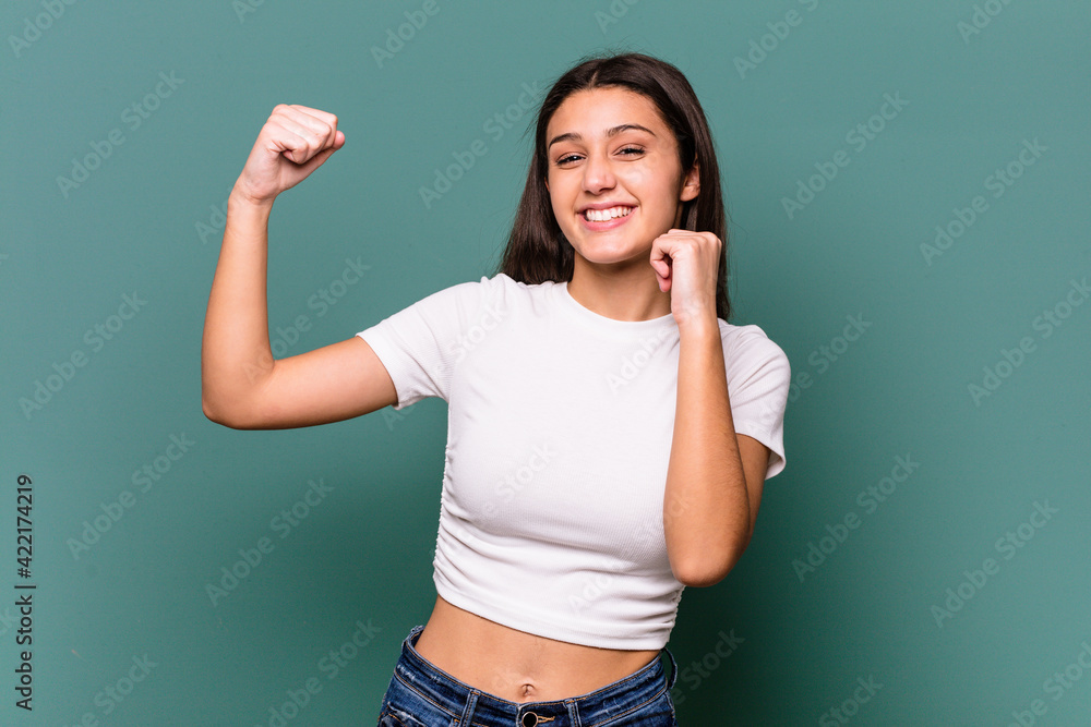 Young Indian woman isolated on blue background dancing and having fun. Young Indian woman isolated on blue background dancing and having fun.