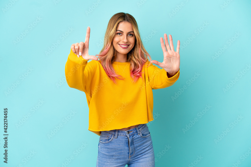 Young woman over isolated blue background counting seven with fingers Young woman over isolated blue background counting seven with fingers