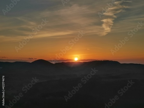 golden sunrise in the mountains with mountain sillouets - czech republic