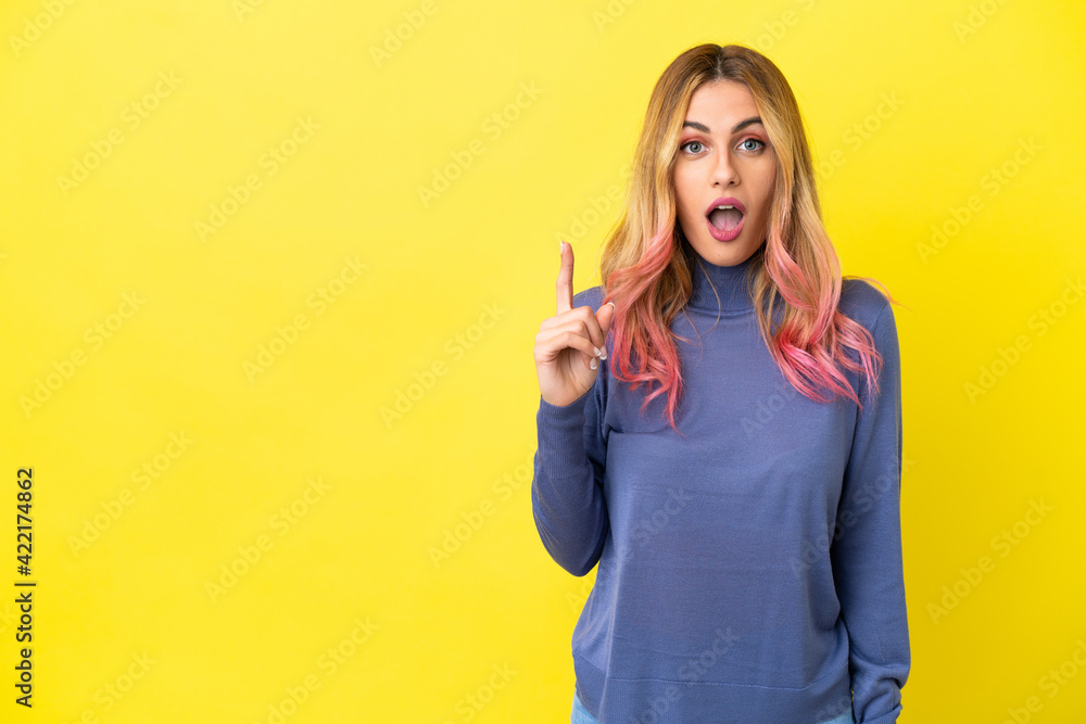 Young woman over isolated yellow background intending to realizes the solution while lifting a finger up Young woman over isolated yellow background intending to realizes the solution while lifting a finger up