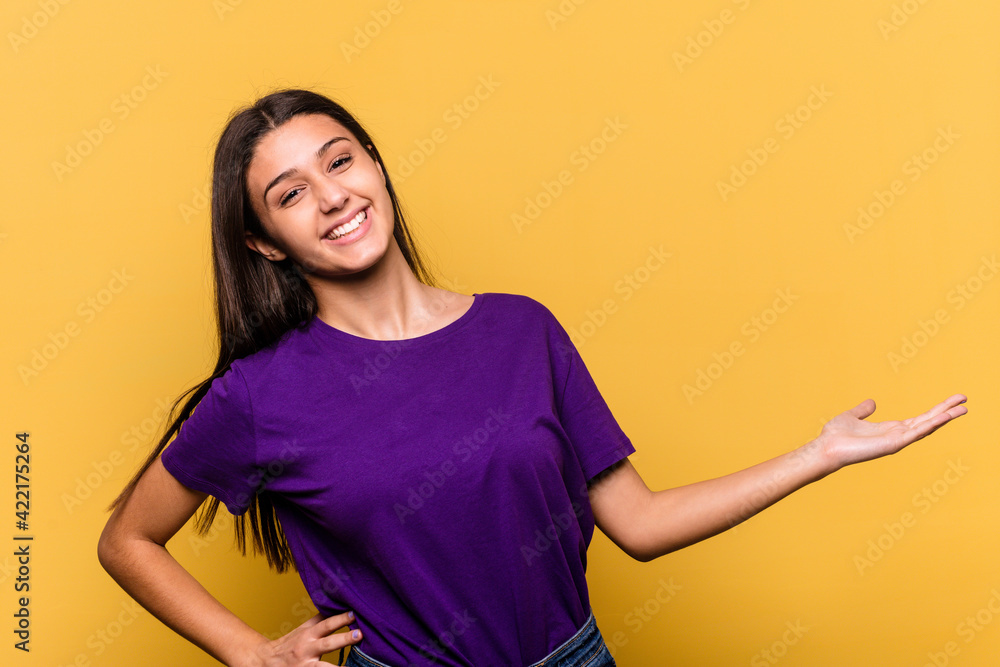 Obraz premium Young Indian woman isolated on yellow background showing a welcome expression.