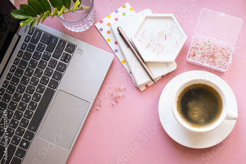 Lady blogger's home workplace, cup of coffee and laptop keyboard on pink tabletop