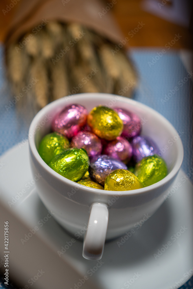 cup with chocolates and dried flowers on a blue background cup with chocolates and dried flowers on a blue background
