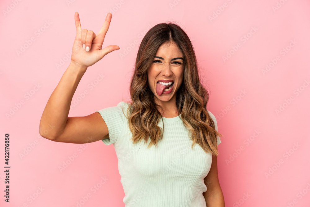 Young caucasian woman isolated showing a horns gesture as a revolution concept.
