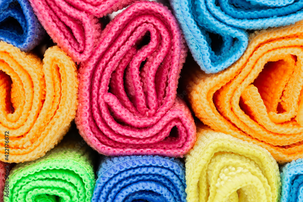 rolled towels in various colors such as pink, yellow, pink and blue for hotels, holiday, spa and hygiene as coloured background rolled towels in various colors such as pink, yellow, pink and blue for hotels, holiday, spa and hygiene as coloured background