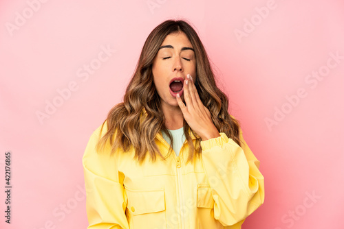 Young caucasian woman isolated yawning showing a tired gesture covering mouth with hand. photo