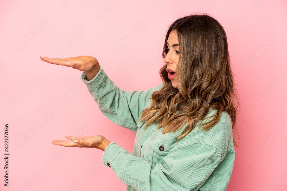 Young caucasian woman isolated shocked and amazed holding a copy space between hands. Young caucasian woman isolated shocked and amazed holding a copy space between hands.