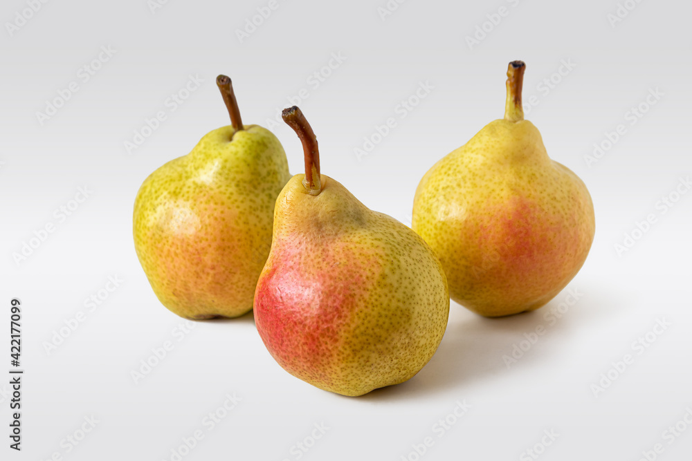 Three fresh yellow-red pears on a light background Three fresh yellow-red pears on a light background