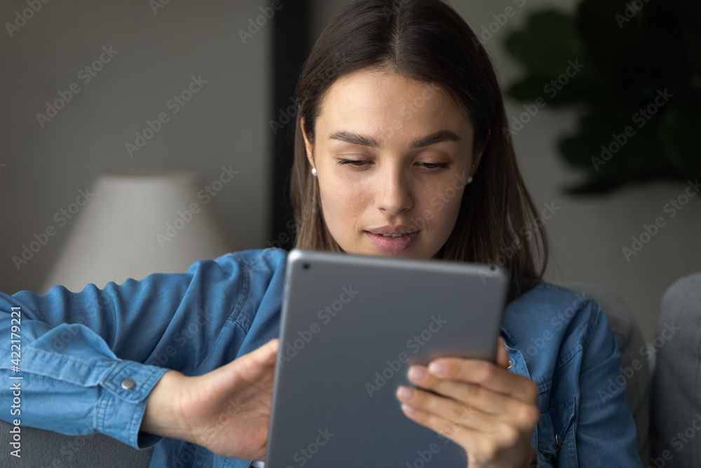Close up focused woman looking at tablet screen, typing, writing message, chatting in social network with friends, customer shopping online, browsing apps, spending leisure time with gadget Close up focused woman looking at tablet screen, typing, writing message, chatting in social network with friends, customer shopping online, browsing apps, spending leisure time with gadget
