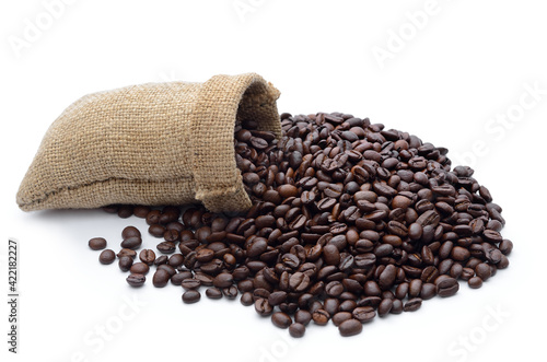 Coffee beans from full sack scattered on white background