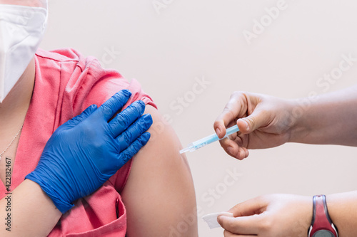 Close up of nurse hands giving vaccine to patient