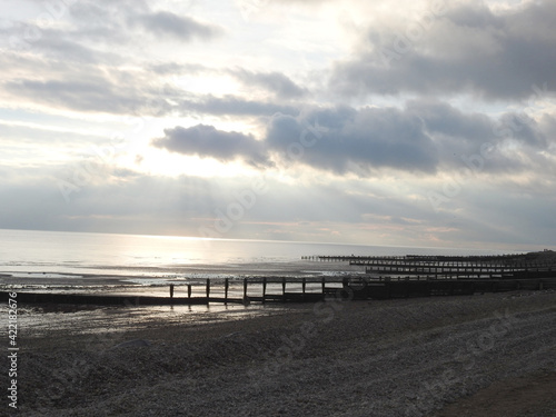 The sun over the sea at sunset obscured by clouds