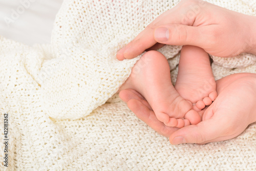 Baby feet in male hands with soft background, close-up. Father's day concept