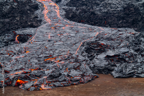 GELDINGADALIR, ICELAND - MARCH 21, 2021: A small volcanic eruption started at the Reykjanes peninsula. The event has attracted thousands of visitors who have braved a daring hike to the crater.