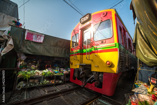 Umbrella Fresh Market on the Railroad Track, Mae Klong Train Station, Bangkok, Thailand on a Sunny Day © kaycco