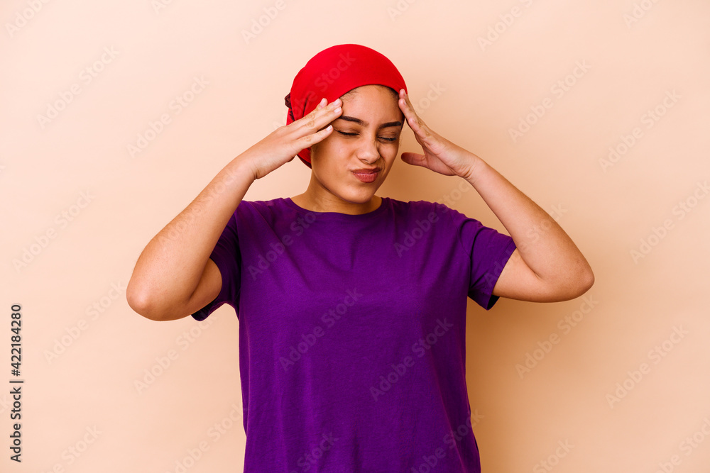 Young african american woman isolated on beige background having a head ache, touching front of the face. Young african american woman isolated on beige background having a head ache, touching front of the face.