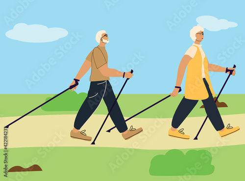 An elderly couple is engaged in Scandinavian walking in nature, in the park.