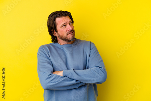 Middle age caucasian man isolated on yellow background tired of a repetitive task.