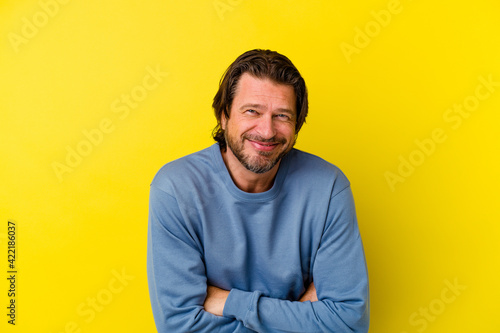 Middle age caucasian man isolated on yellow background laughing and having fun.