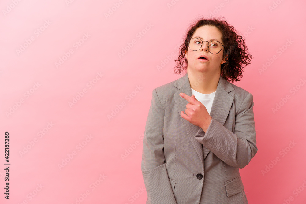 Business woman with Down syndrome isolated on pink background pointing to the side Business woman with Down syndrome isolated on pink background pointing to the side