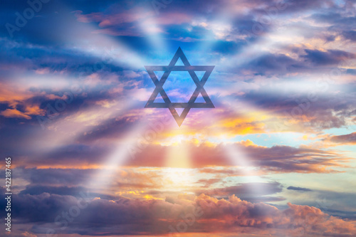 Judaism logo on sky background. Star of David as a symbol of Jewish religion. Symbol of Judaism religion. Jewish religion. Concept - visits to Jewish Senagogue. Star of David emits rays of light. photo