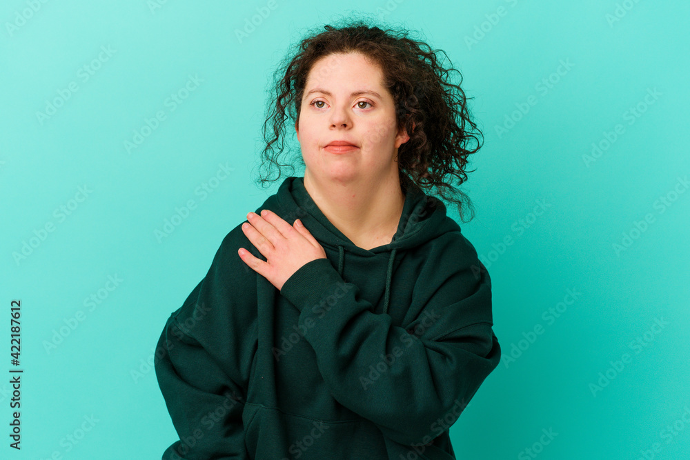 Woman with Down syndrome isolated having a shoulder pain. Woman with Down syndrome isolated having a shoulder pain.