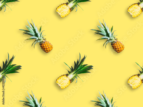 Seamless pattern of ripe pineapples isolated on yellow background. Top view. Exotic tropical fruit summer concept.