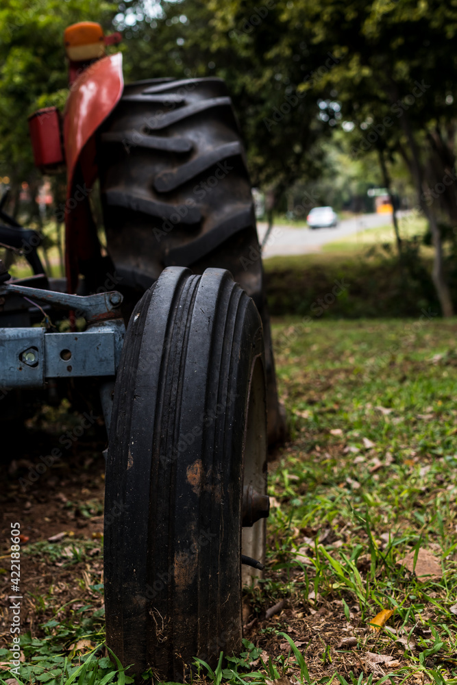 Fototapeta premium Worn out tyres of a very old red tractor