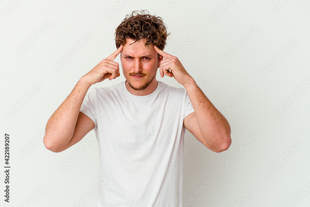 Young caucasian man isolated on white background focused on a task, keeping forefingers pointing head. Young caucasian man isolated on white background focused on a task, keeping forefingers pointing head.