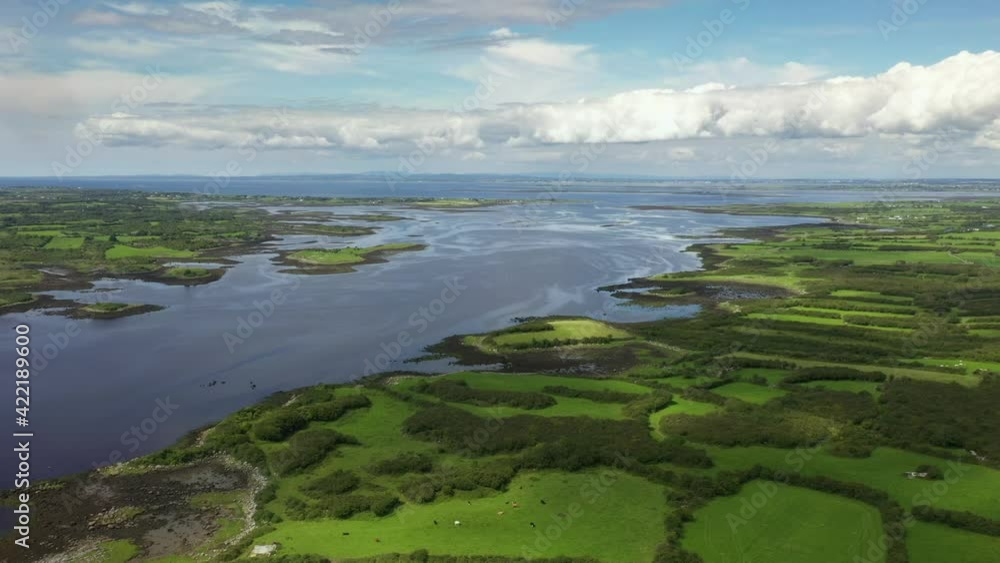 Irish Rural Landscape, view from Kinvara Bay looking North towards Galway Bay, Ireland, August 2020, Drone gradually pulls backward over green fields revealing coastal inlet with yachts and boats. Irish Rural Landscape, view from Kinvara Bay looking North towards Galway Bay, Ireland, August 2020, Drone gradually pulls backward over green fields revealing coastal inlet with yachts and boats.