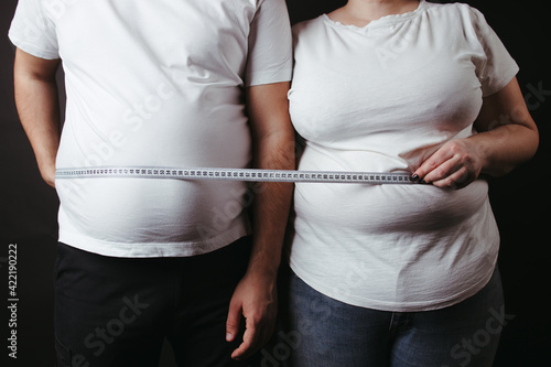 Overweight fat couple wrapped with measure tape