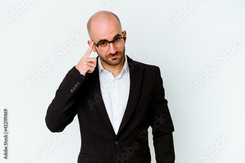Young business caucasian bald man isolated on blue background pointing temple with finger, thinking, focused on a task.