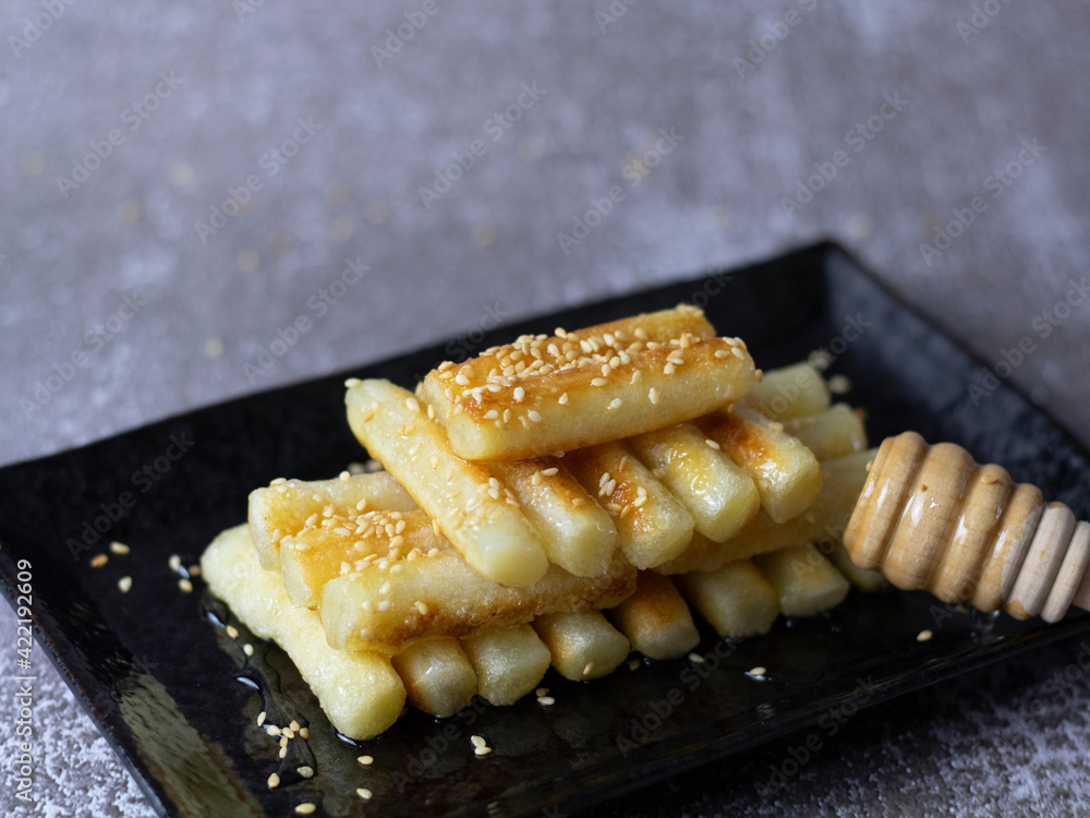 Korean Rice Cakes with Honey (Garaetteok). Dripping honey on tteokbokki