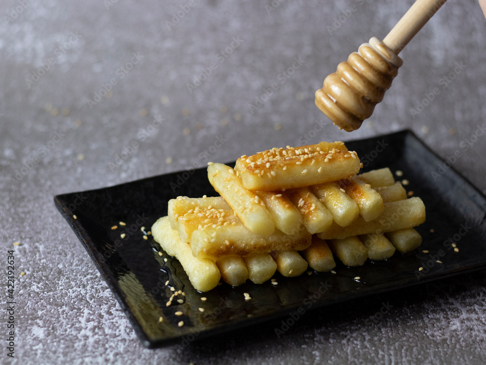 Korean Rice Cakes with Honey (Garaetteok). Dripping honey on tteokbokki