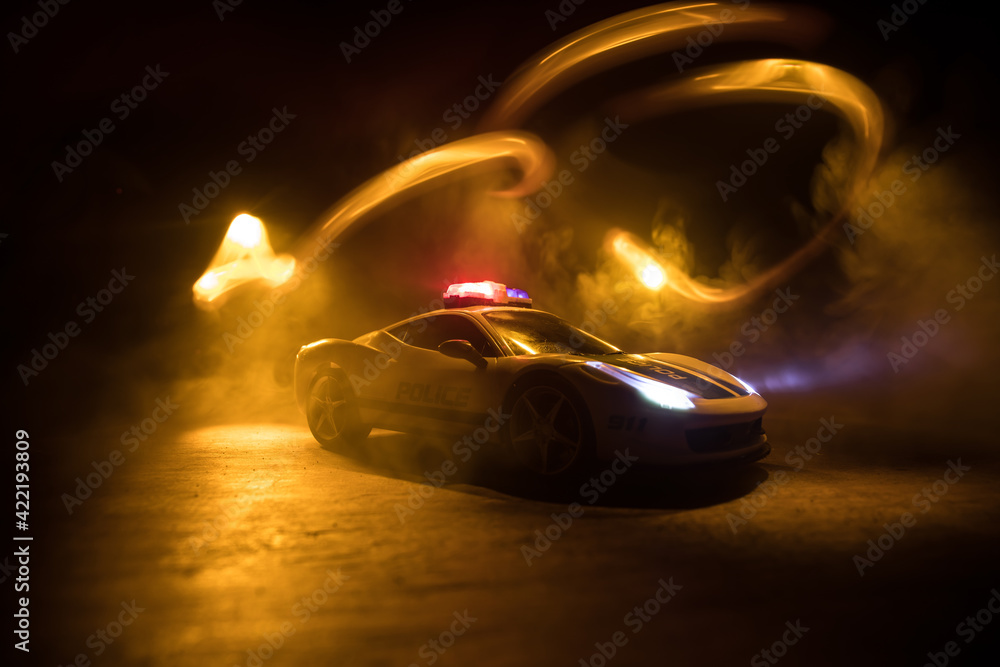 Police car chasing a car at night with fog background. 911 Emergency response police car speeding to scene of crime. Selective focus Police car chasing a car at night with fog background. 911 Emergency response police car speeding to scene of crime. Selective focus