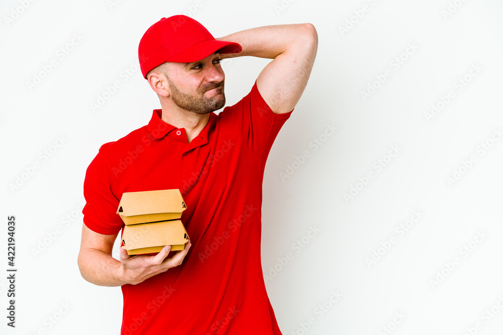 Young caucasian delivery man isolated on white background touching back of head, thinking and making a choice. Young caucasian delivery man isolated on white background touching back of head, thinking and making a choice.