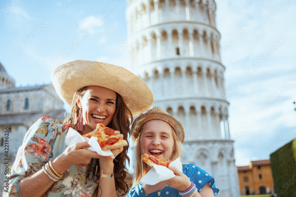 Portrait of smiling elegant mother and daughter with pizza