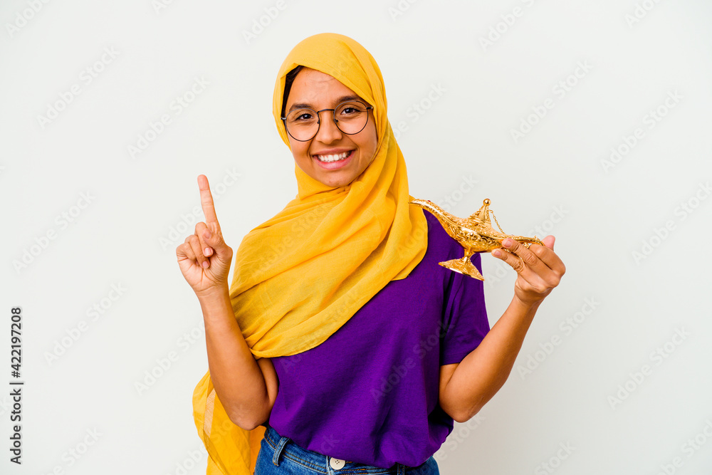 Young muslim woman holding a lamp isolated on white background having some great idea, concept of creativity. Young muslim woman holding a lamp isolated on white background having some great idea, concept of creativity.