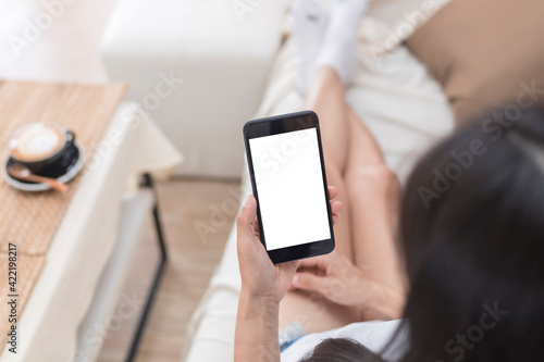 Close up hands of woman using mobile phone, cell phone in coffee shop. Hands of women holding blank empty screen smart phone in cafe. Women relax with mobile phone sit in restaurant