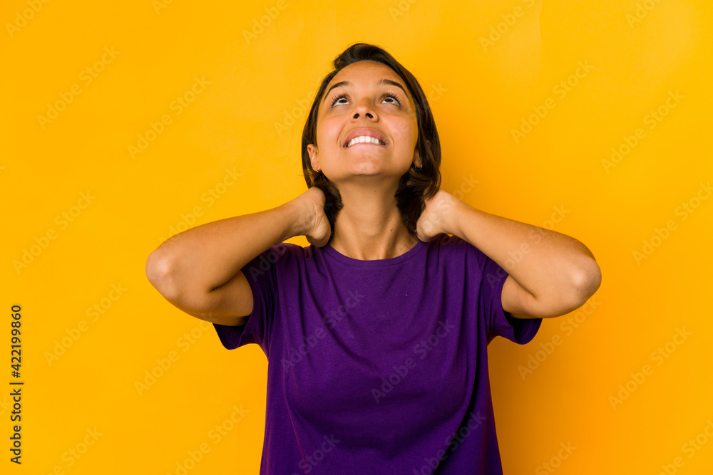 Young hispanic woman isolated on yellow feeling confident, with hands behind the head. Young hispanic woman isolated on yellow feeling confident, with hands behind the head.