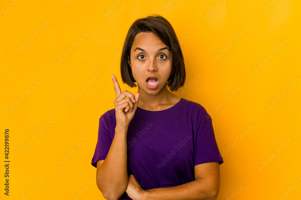 Young hispanic woman isolated on yellow having an idea, inspiration concept.