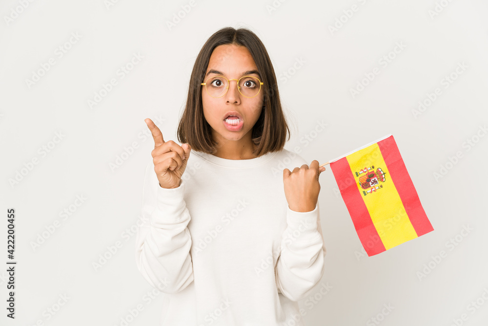 Young hispanic mixed race woman holding a spanish flag having an idea, inspiration concept. Young hispanic mixed race woman holding a spanish flag having an idea, inspiration concept.