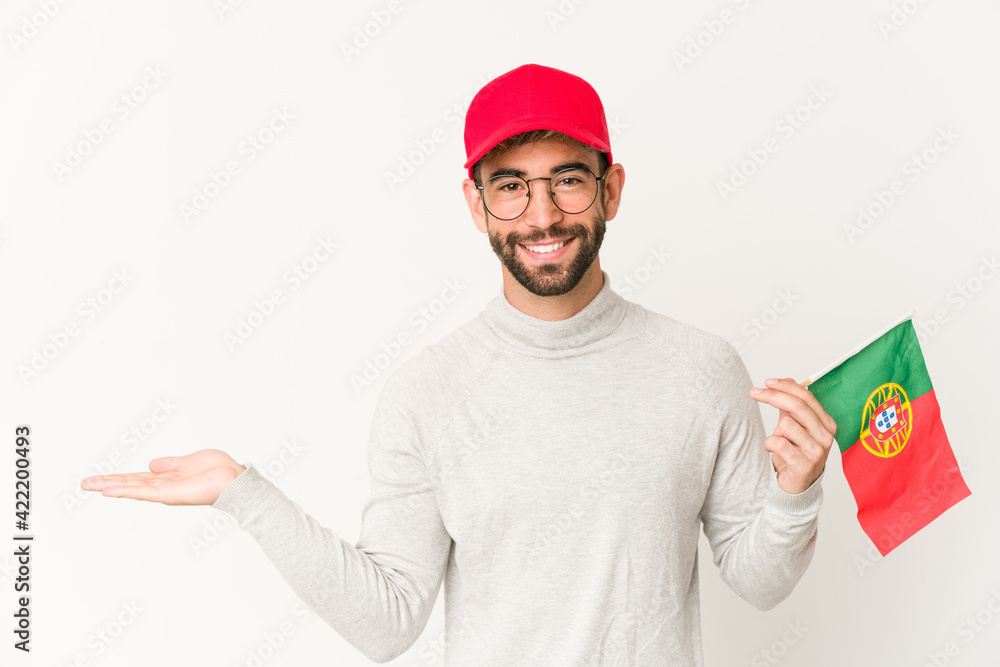 Young hispanic mixed race woman holding a portugal flag showing a copy space on a palm and holding another hand on waist. Young hispanic mixed race woman holding a portugal flag showing a copy space on a palm and holding another hand on waist.